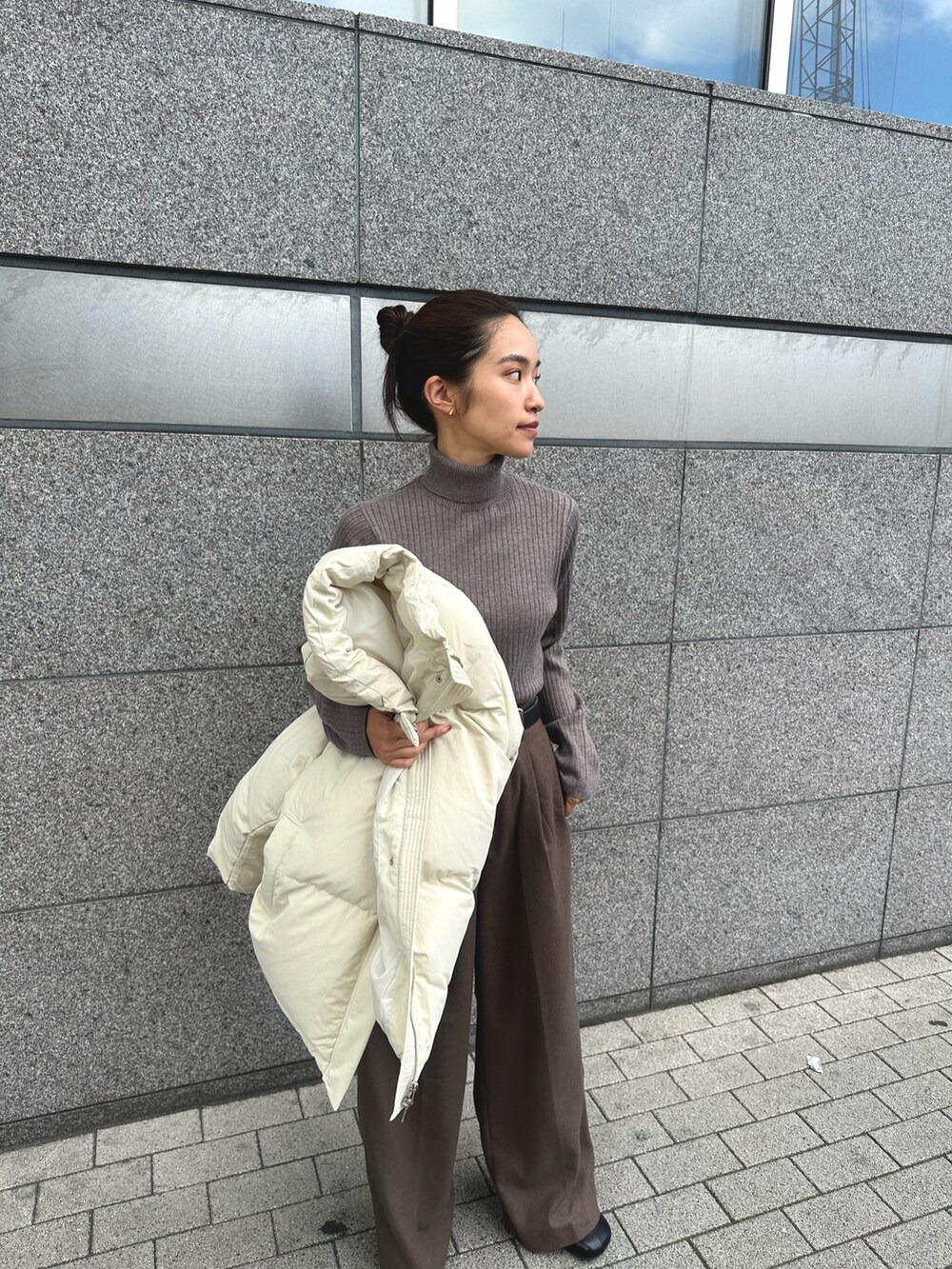 ホワイト系のダウンジャケット/コート、グレー系のニット/セーター、ブラウン系のその他パンツを着用したレディースの秋コーディネートの7枚目の写真