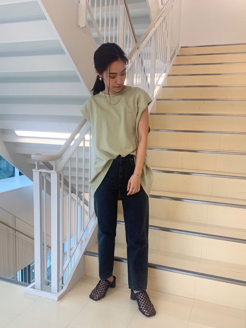 ブラック系のサンダル、ブラック系のデニムパンツ、グリーン系のTシャツ/カットソーを着用したレディースの夏コーディネートの2枚目の写真