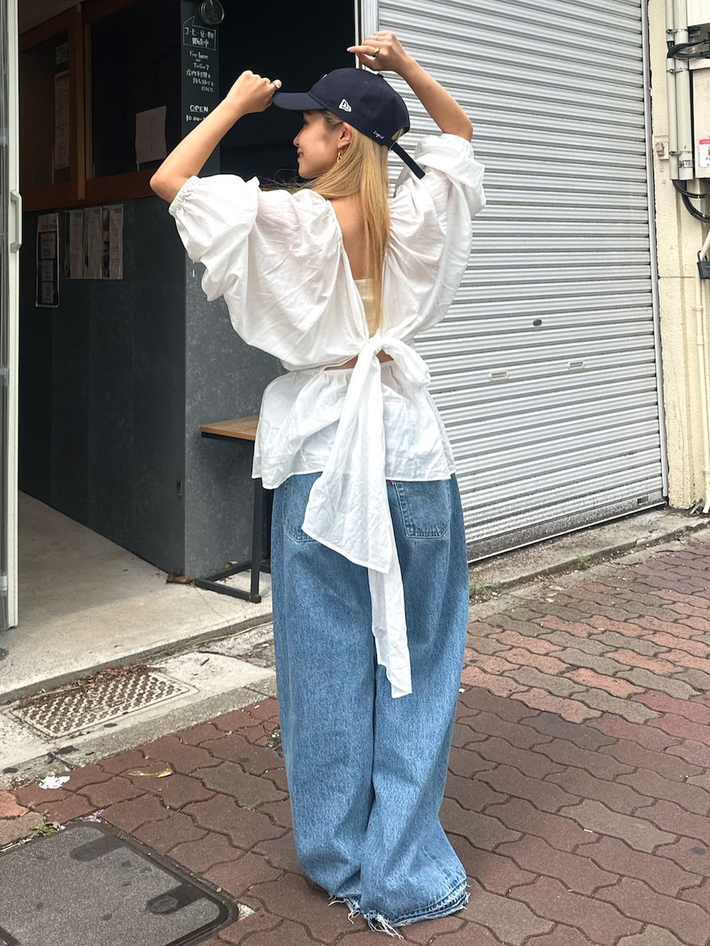 ホワイト系のシャツ/ブラウス、ブルー系のデニムパンツ、ブルー系のキャップを着用したレディースの夏コーディネートの4枚目の写真