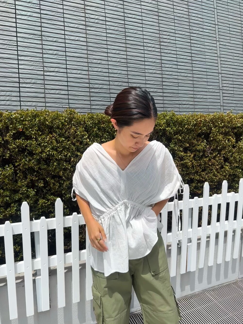 ホワイト系のシャツ/ブラウス、グリーン系のカーゴパンツ、ゴールド系のサンダルを着用したレディースの夏コーディネートの4枚目の写真