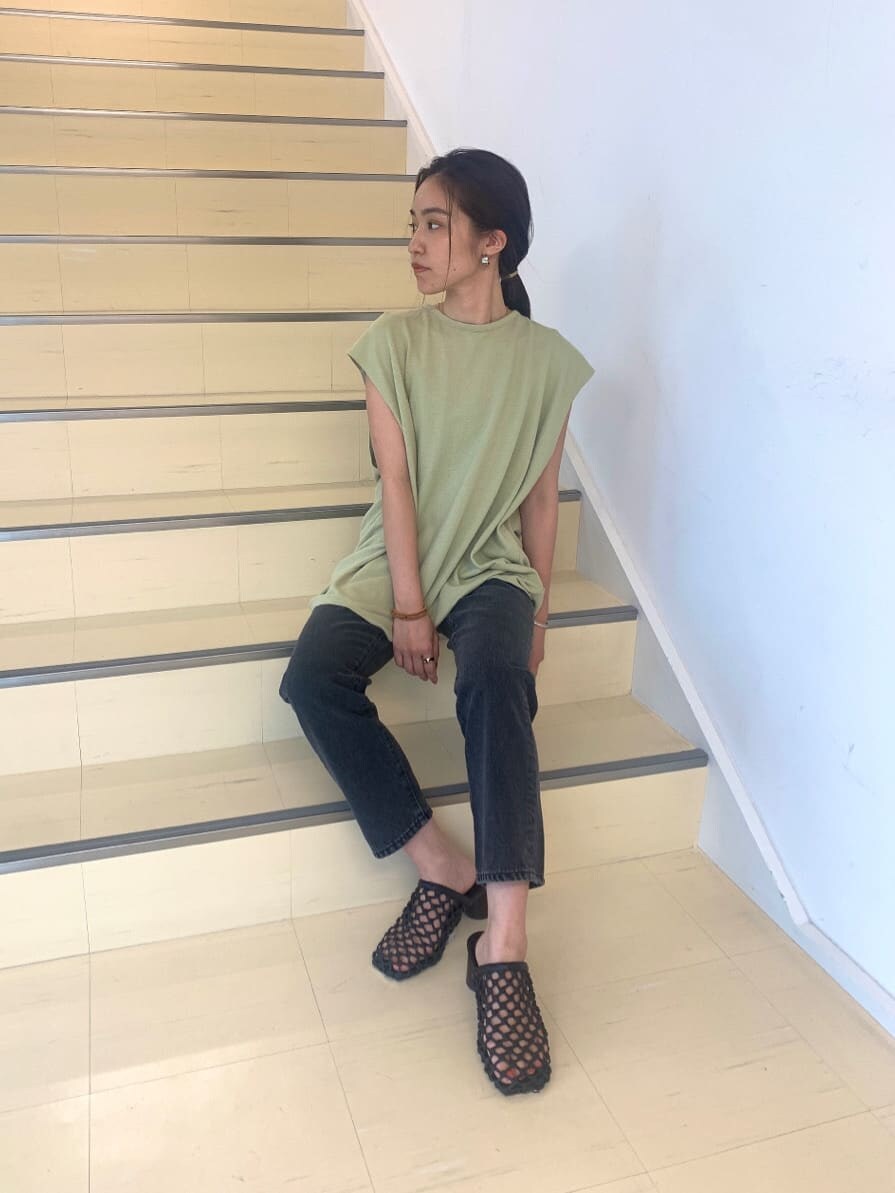 ブラック系のサンダル、ブラック系のデニムパンツ、グリーン系のTシャツ/カットソーを着用したレディースの夏コーディネートの3枚目の写真