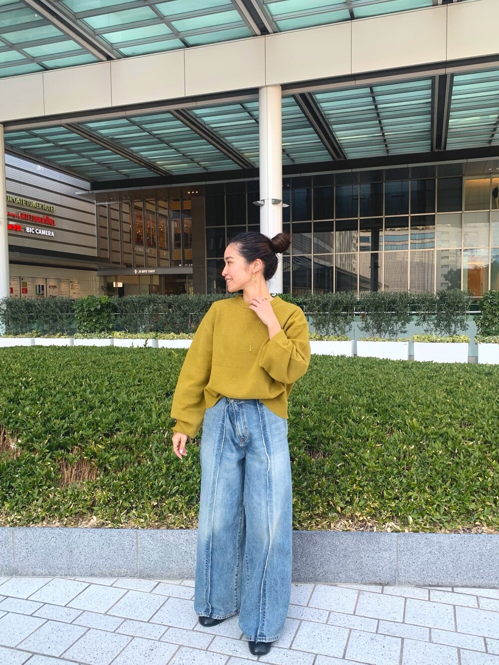 ブラウン系のその他アウター、グリーン系のニット/セーター、ブラック系のブーツを着用したレディースの冬コーディネートの4枚目の写真