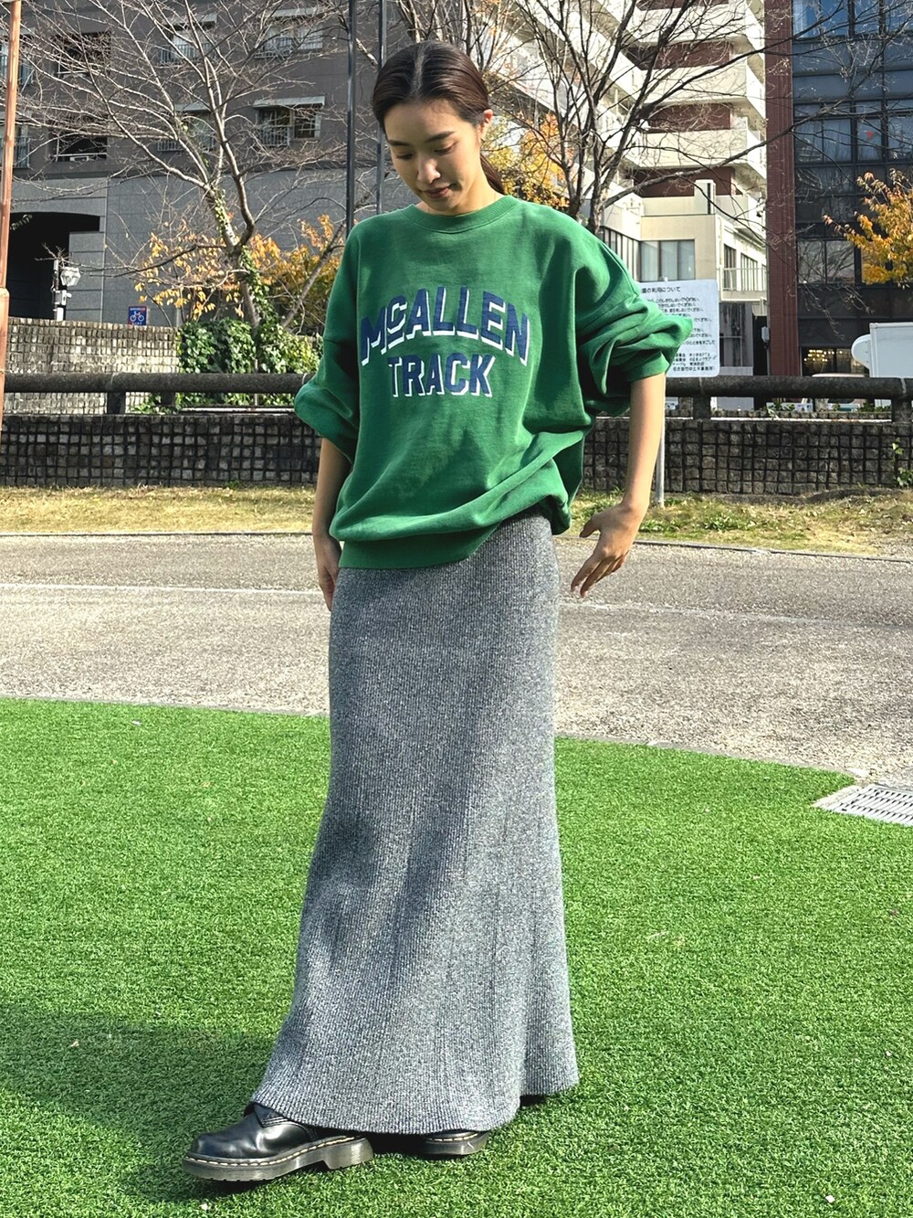 グリーン系のスウェット、グレー系のスカートを着用したレディースの冬コーディネートの4枚目の写真