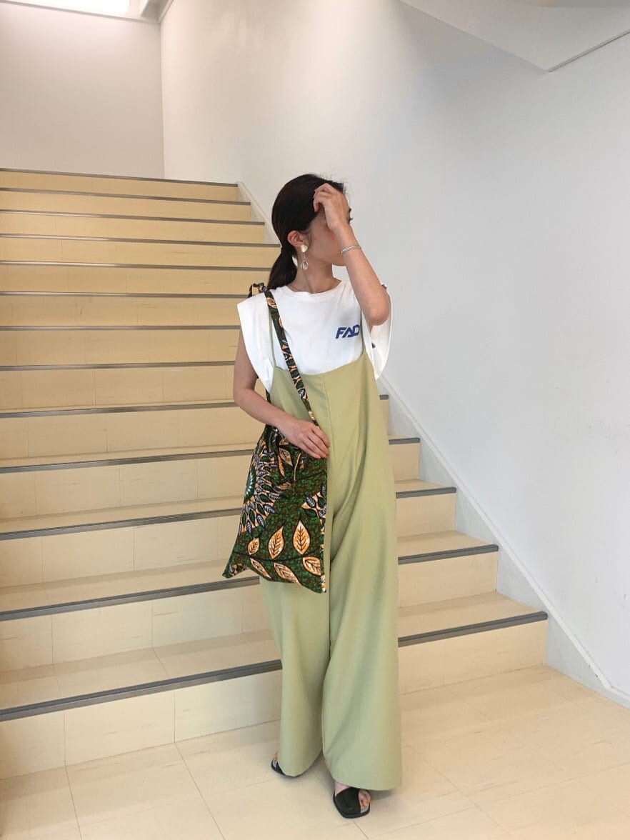 ブラック系のサンダル、ホワイト系のタンクトップ、グリーン系のショルダーバッグを着用したレディースの春コーディネートの3枚目の写真