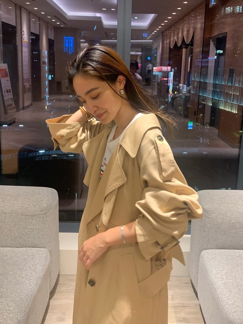 ベージュ系のトレンチコート、グレー系のスラックス、ホワイト系のTシャツ/カットソーを着用したレディースの秋コーディネートの6枚目の写真