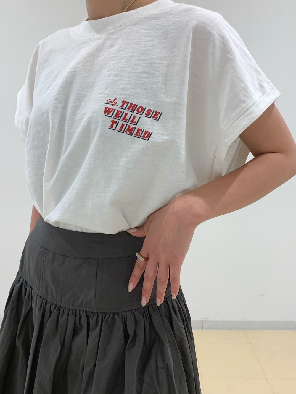ホワイト系のTシャツ/カットソー、グレー系のスカート、ブラック系のサンダルを着用したレディースの春コーディネートの7枚目の写真