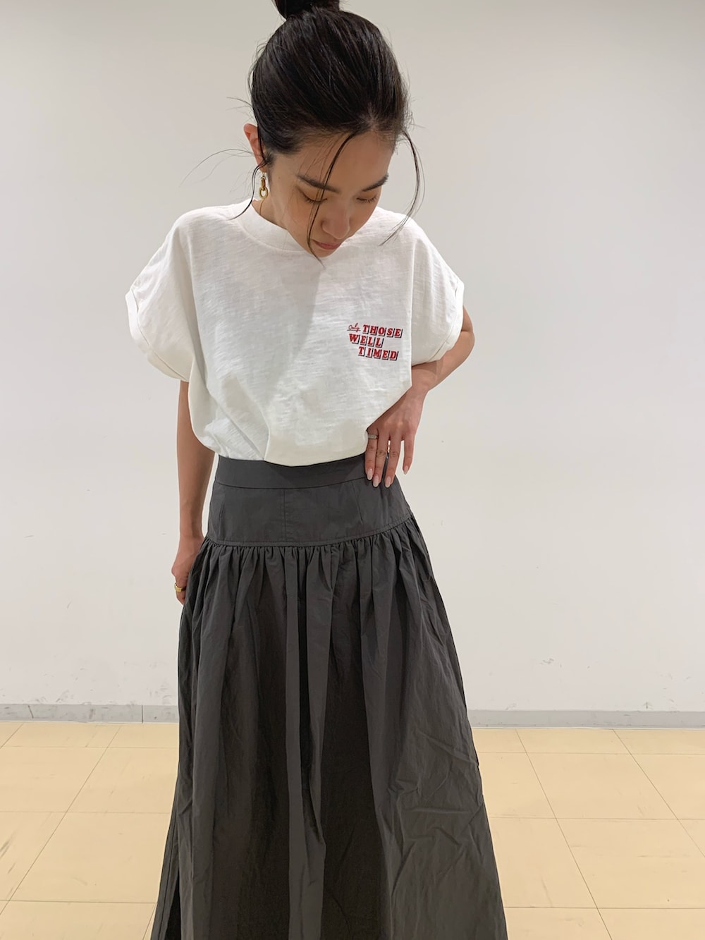 ホワイト系のTシャツ/カットソー、グレー系のスカート、ブラック系のサンダルを着用したレディースの春コーディネートの6枚目の写真