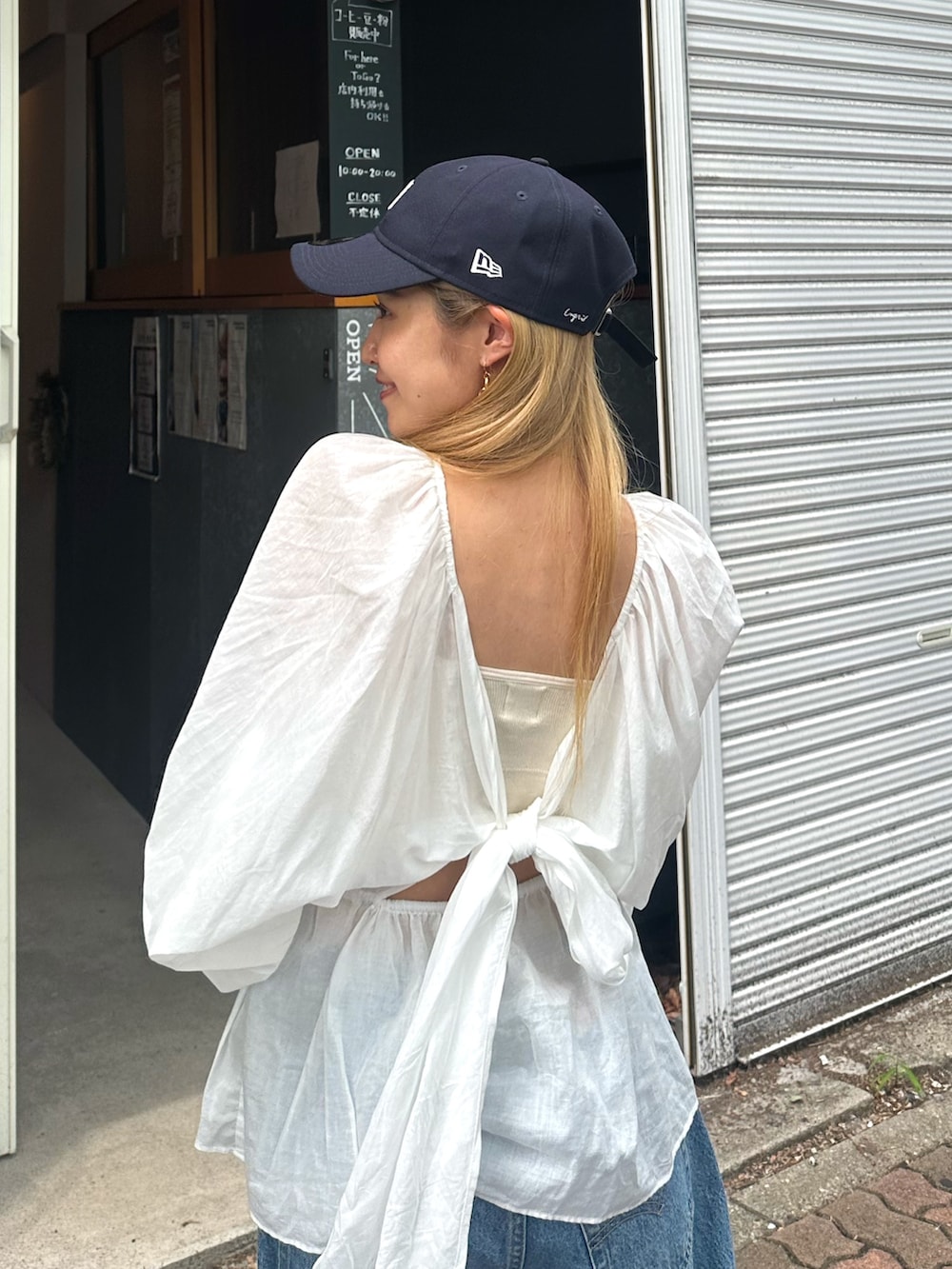 ホワイト系のシャツ/ブラウス、ブルー系のデニムパンツ、ブルー系のキャップを着用したレディースの夏コーディネートの5枚目の写真