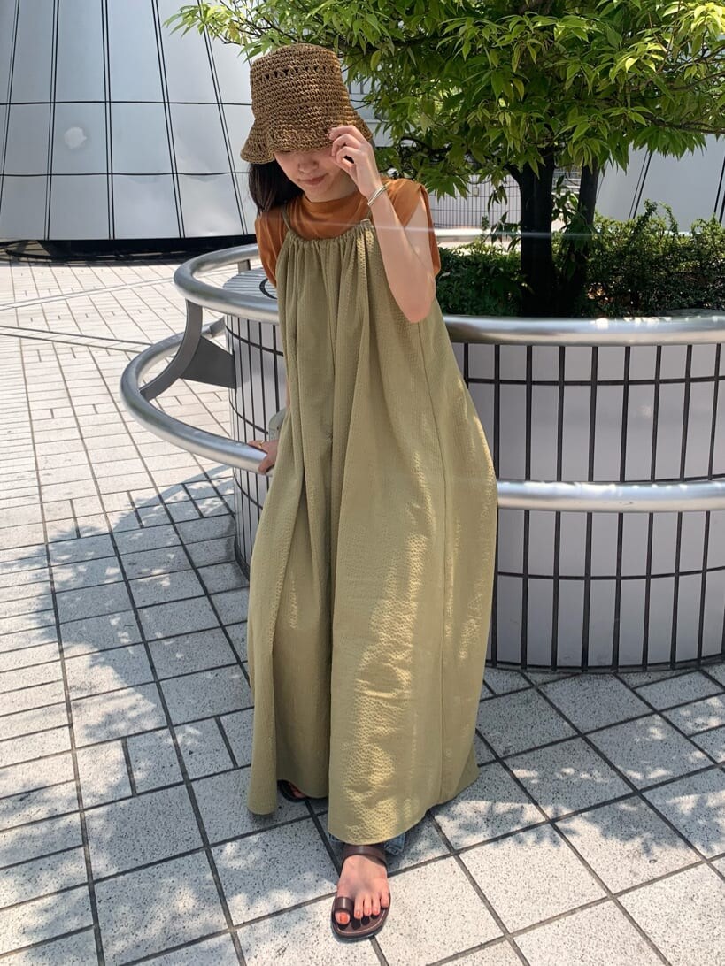 ブルー系のデニムパンツ、グリーン系のワンピース、ブラウン系のサンダルを着用したレディースの夏コーディネートの5枚目の写真