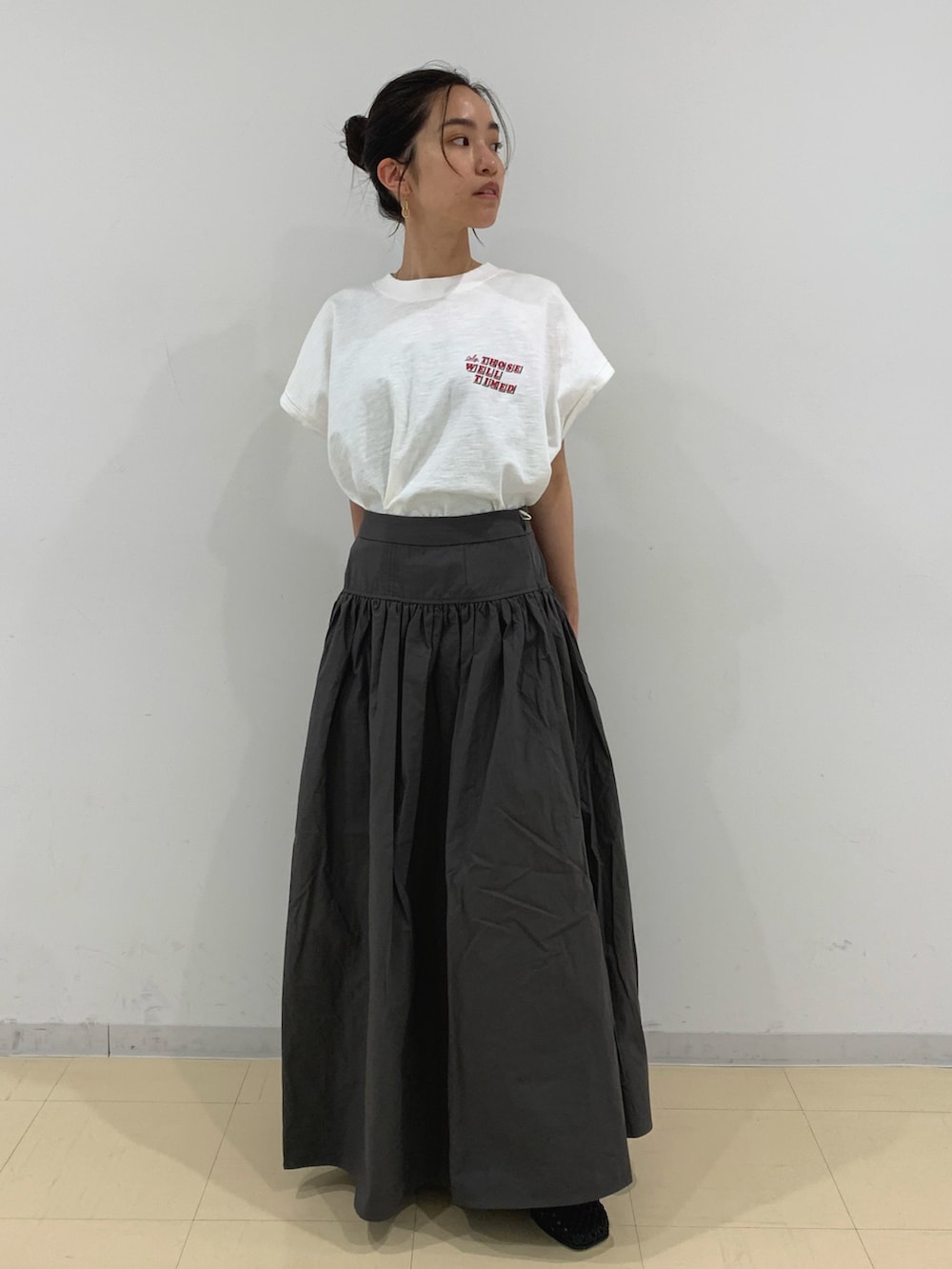 ホワイト系のTシャツ/カットソー、グレー系のスカート、ブラック系のサンダルを着用したレディースの春コーディネートの4枚目の写真