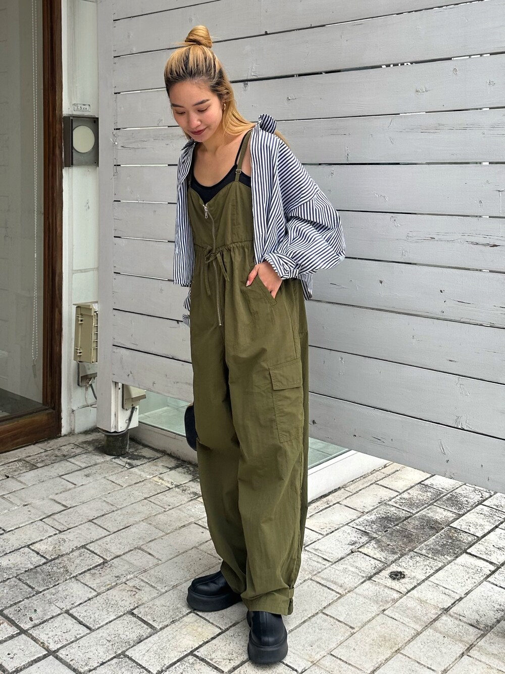 ブラック系のシャツ/ブラウス、グリーン系のサロペット/オーバーオールを着用したレディースの冬コーディネートの3枚目の写真