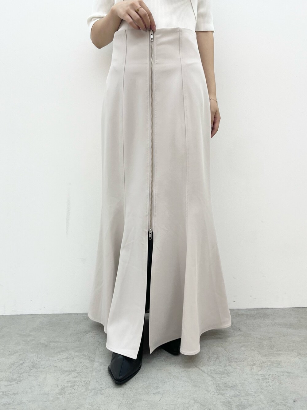 ホワイト系のニット/セーター、グレー系のスカートを着用したレディースの夏コーディネートの5枚目の写真