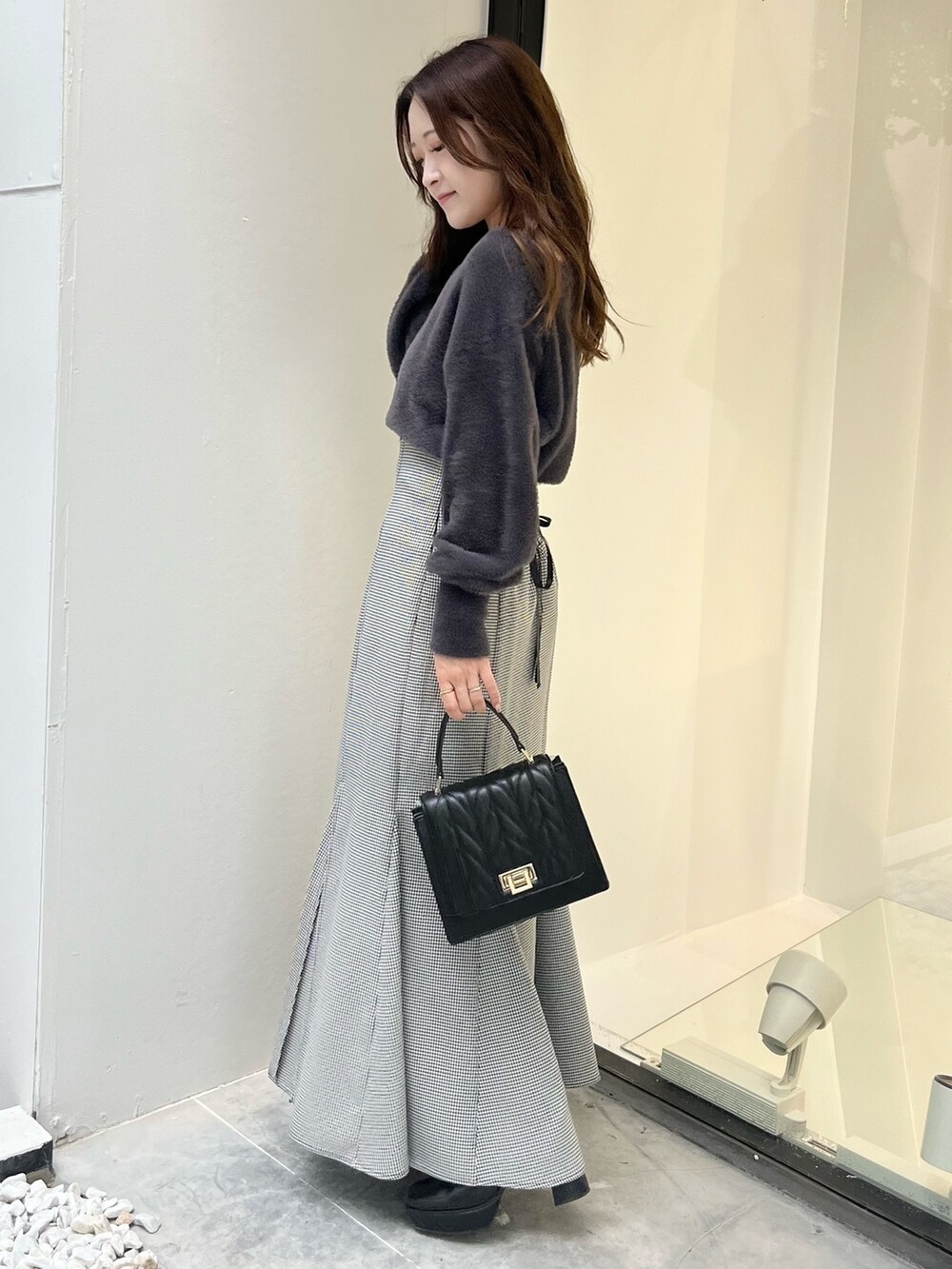 その他のスカート、グレー系のカーディガン/ボレロ、ブラック系のショルダーバッグを着用したレディースの秋コーディネートの2枚目の写真