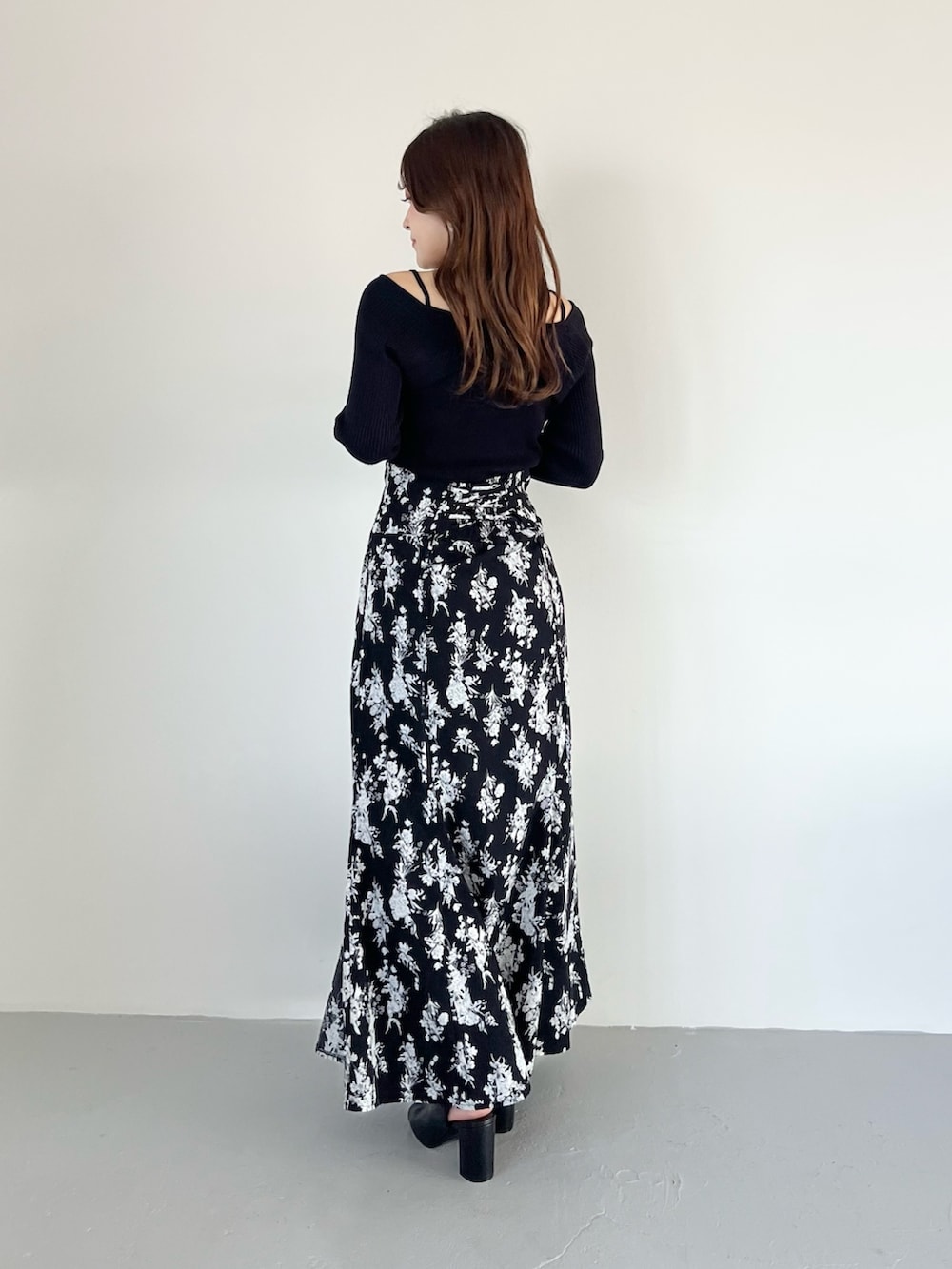 ブラック系のスカート、ブルー系のニット/セーター、ブラック系のブーツを着用したレディースの春コーディネートの3枚目の写真