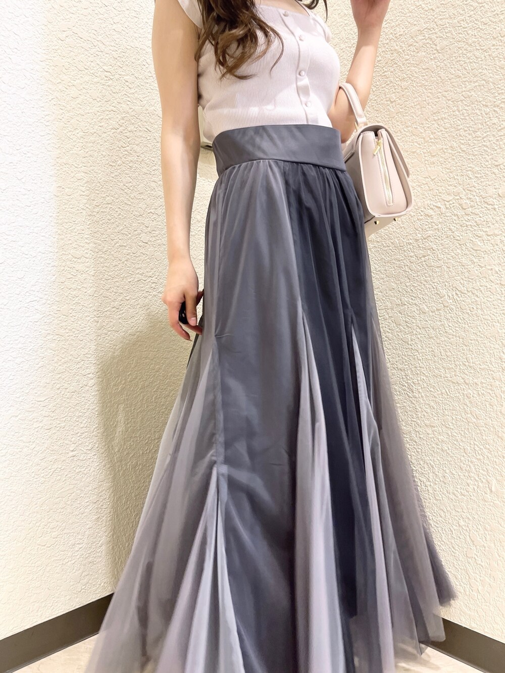 ピンク系のニット/セーター、ブラック系のスカート、ピンク系のショルダーバッグを着用したレディースの春コーディネートの7枚目の写真