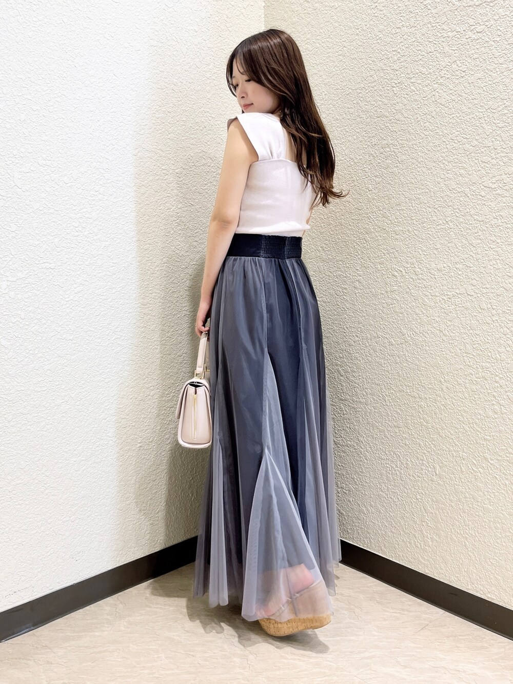 ピンク系のニット/セーター、ブラック系のスカート、ピンク系のショルダーバッグを着用したレディースの春コーディネートの3枚目の写真