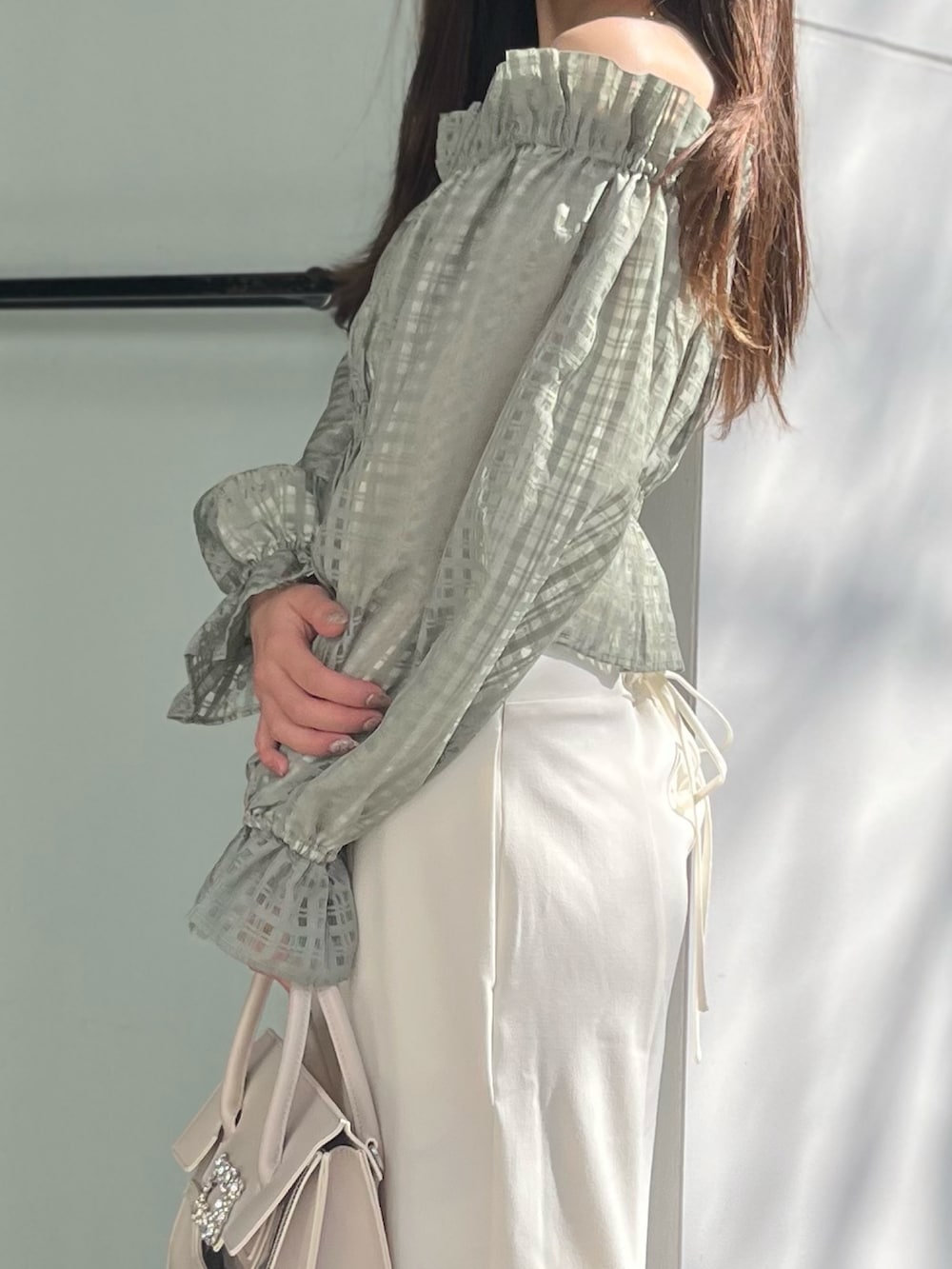 ホワイト系のスカート、グリーン系のシャツ/ブラウス、ベージュ系のショルダーバッグを着用したレディースの冬コーディネートの7枚目の写真