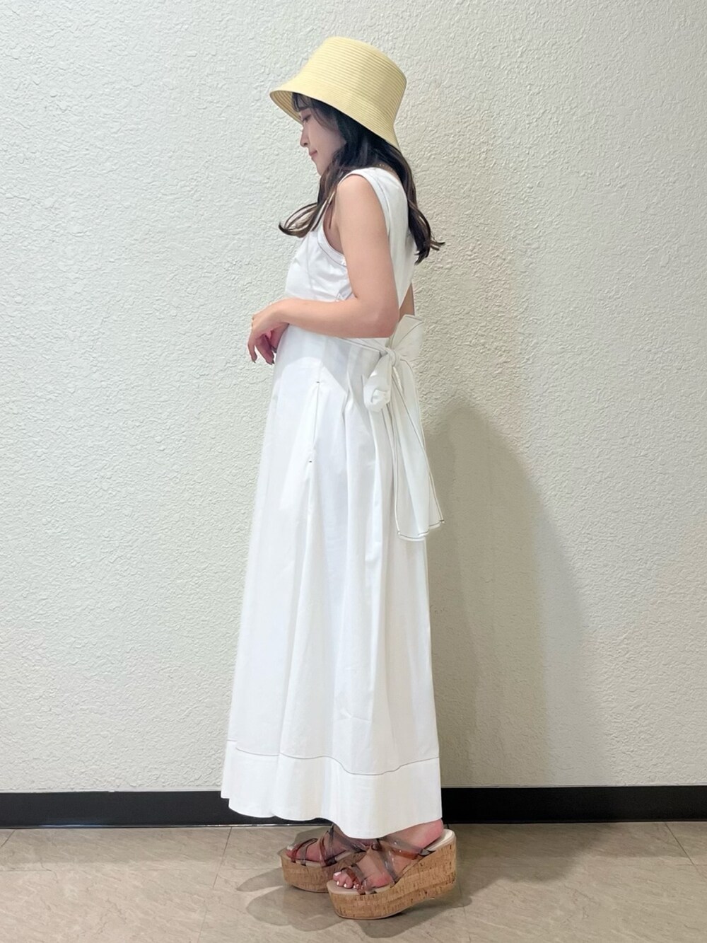 ホワイト系のワンピース、その他のサンダル、ベージュ系のハットを着用したレディースの春コーディネートの2枚目の写真