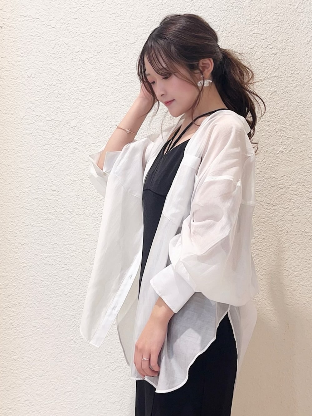 ブラック系のワンピース、ブラック系のサンダル、ホワイト系のシャツ/ブラウスを着用したレディースの春コーディネートの2枚目の写真