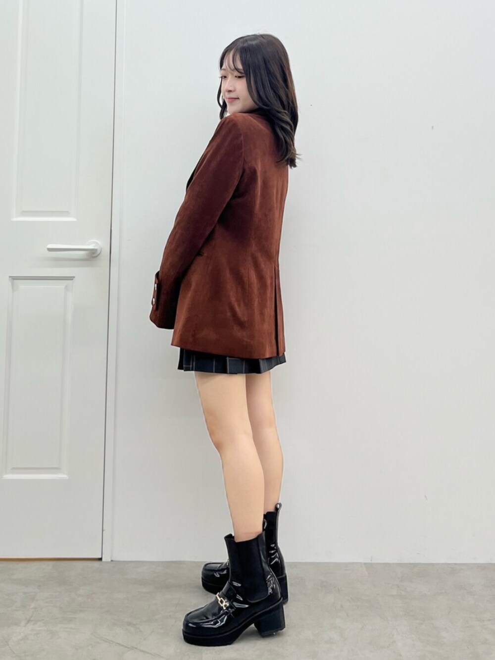 ブラウン系のテーラードジャケット、グリーン系のスカートを着用したレディースの秋コーディネートの2枚目の写真