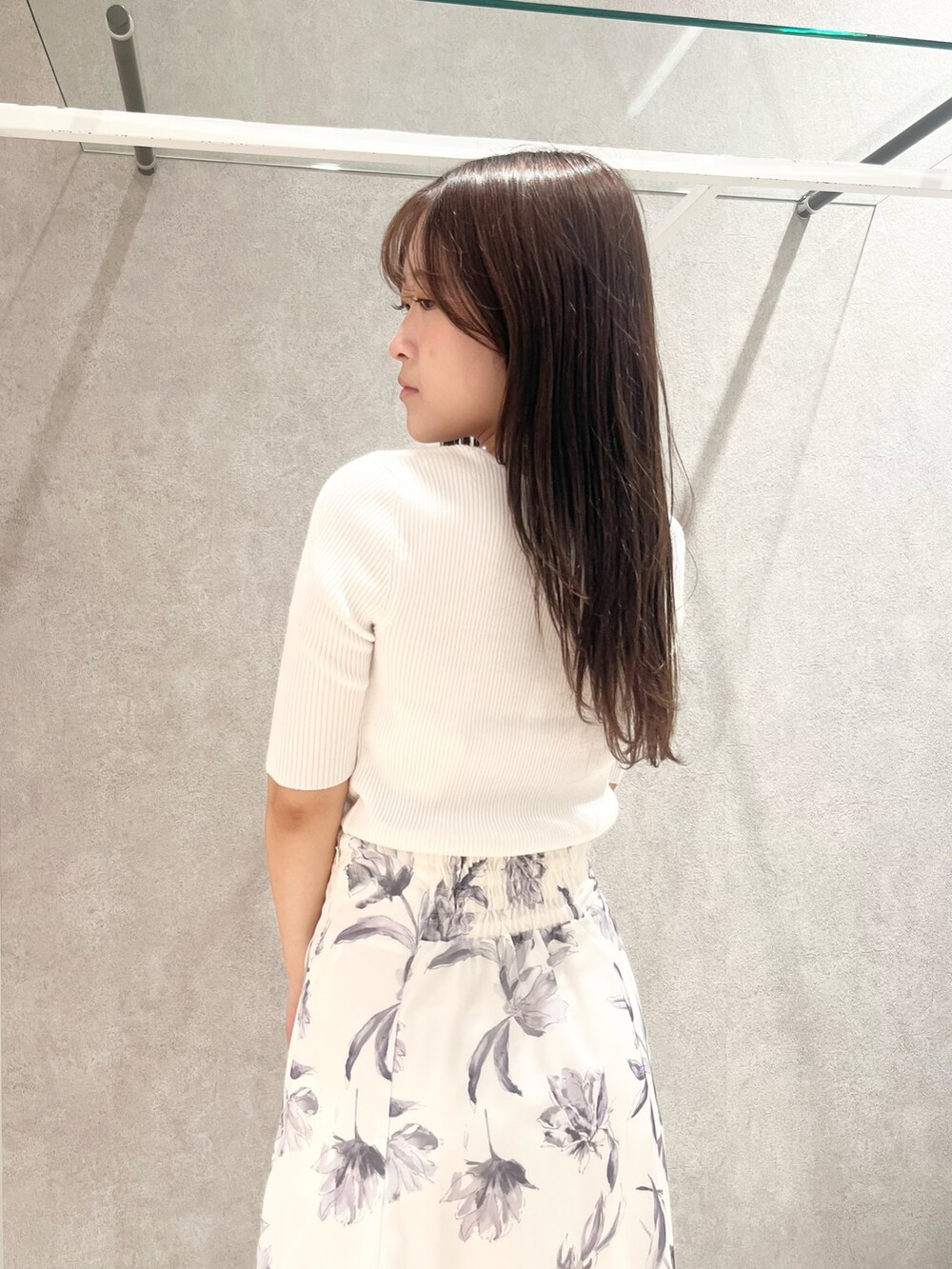 ホワイト系のニット/セーター、グレー系のスカート、ベージュ系のショルダーバッグを着用したレディースの春コーディネートの7枚目の写真