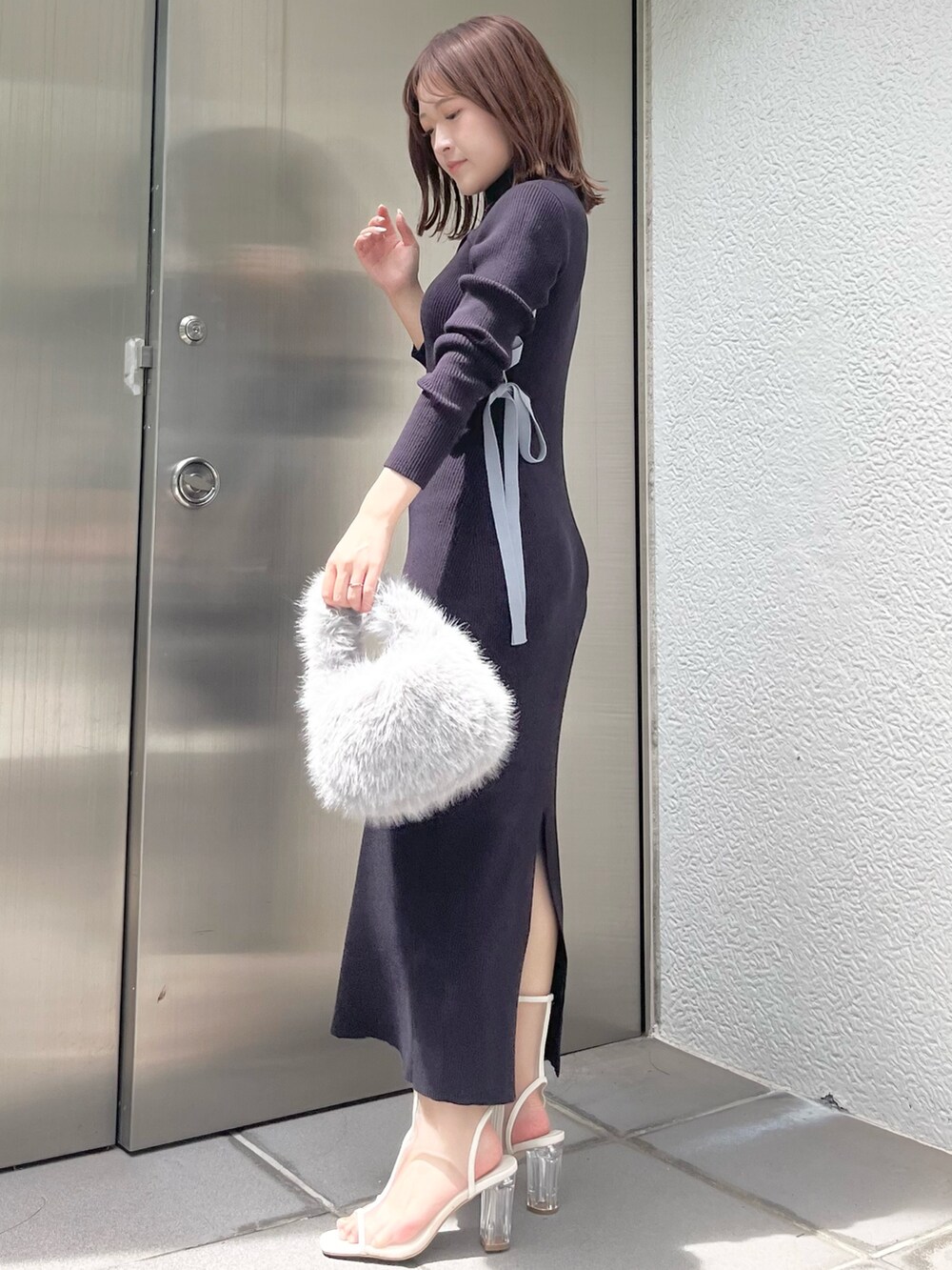 ブルー系のワンピース、グレー系のハンドバッグ、ホワイト系のブーツを着用したレディースの夏コーディネートの2枚目の写真