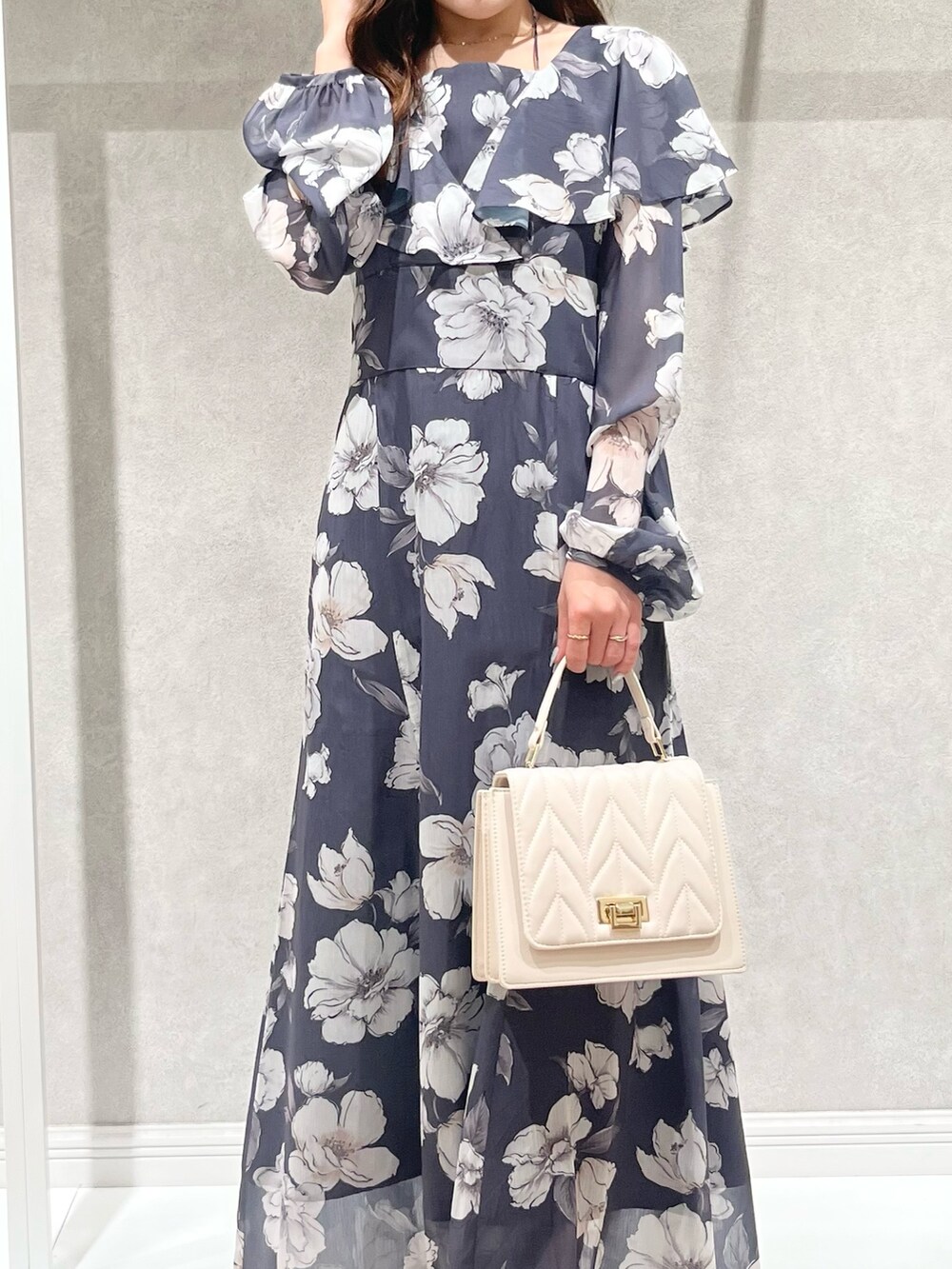 パープル系のチェスターコート、グレー系のワンピース、ホワイト系のショルダーバッグを着用したレディースの秋コーディネートの4枚目の写真