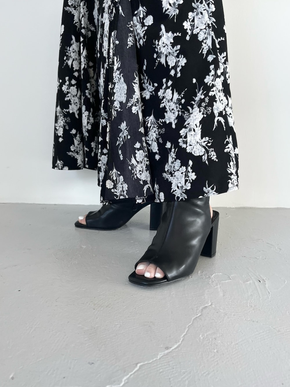 ブラック系のスカート、ブルー系のニット/セーター、ブラック系のブーツを着用したレディースの春コーディネートの6枚目の写真