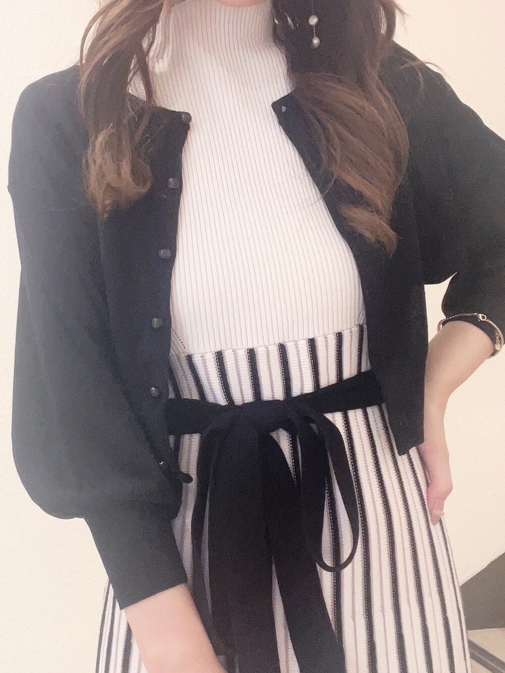 ホワイト系のワンピース、ブラック系のカーディガン/ボレロ、その他のサンダルを着用したレディースの春コーディネートの4枚目の写真