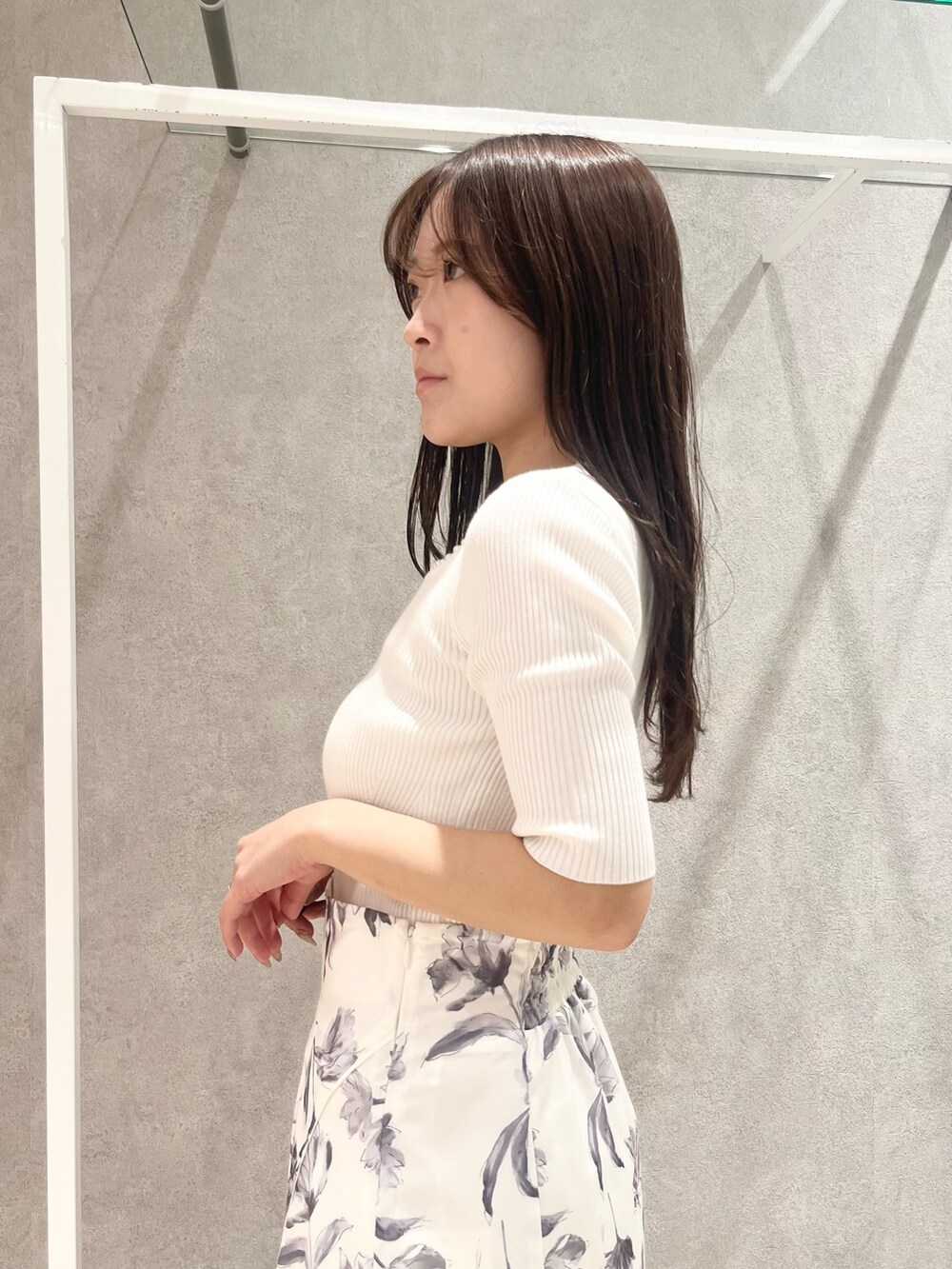 ホワイト系のニット/セーター、グレー系のスカート、ベージュ系のショルダーバッグを着用したレディースの春コーディネートの6枚目の写真