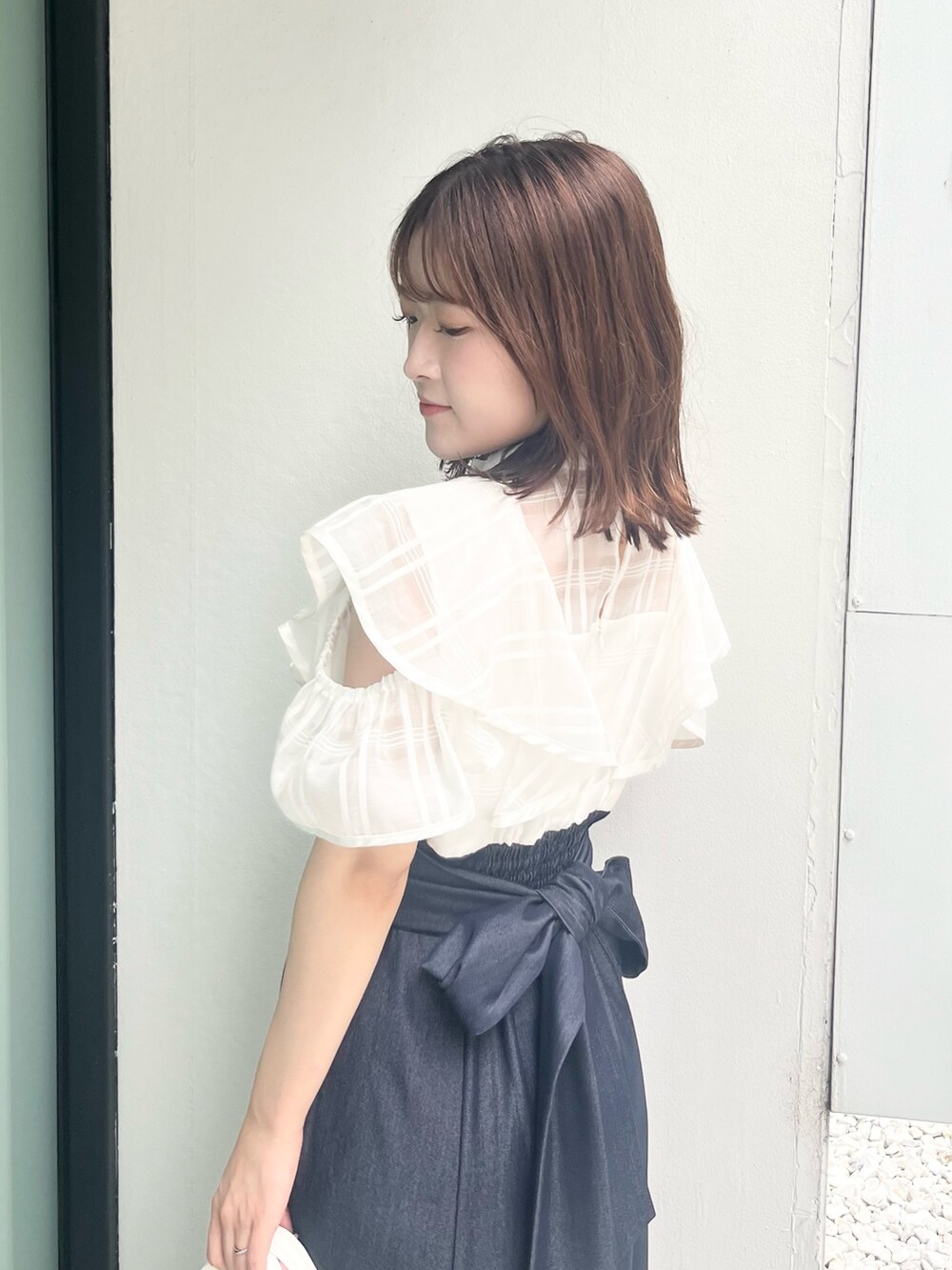 ホワイト系のワンピース、ホワイト系のハンドバッグ、ブラウン系のサンダルを着用したレディースの夏コーディネートの6枚目の写真