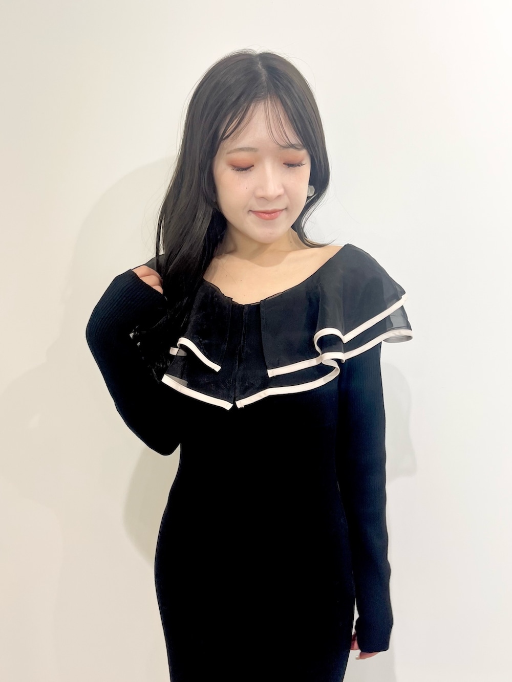 ブラック系のワンピース、ブラック系のショルダーバッグ、ブラック系のブーツを着用したレディースの冬コーディネートの6枚目の写真