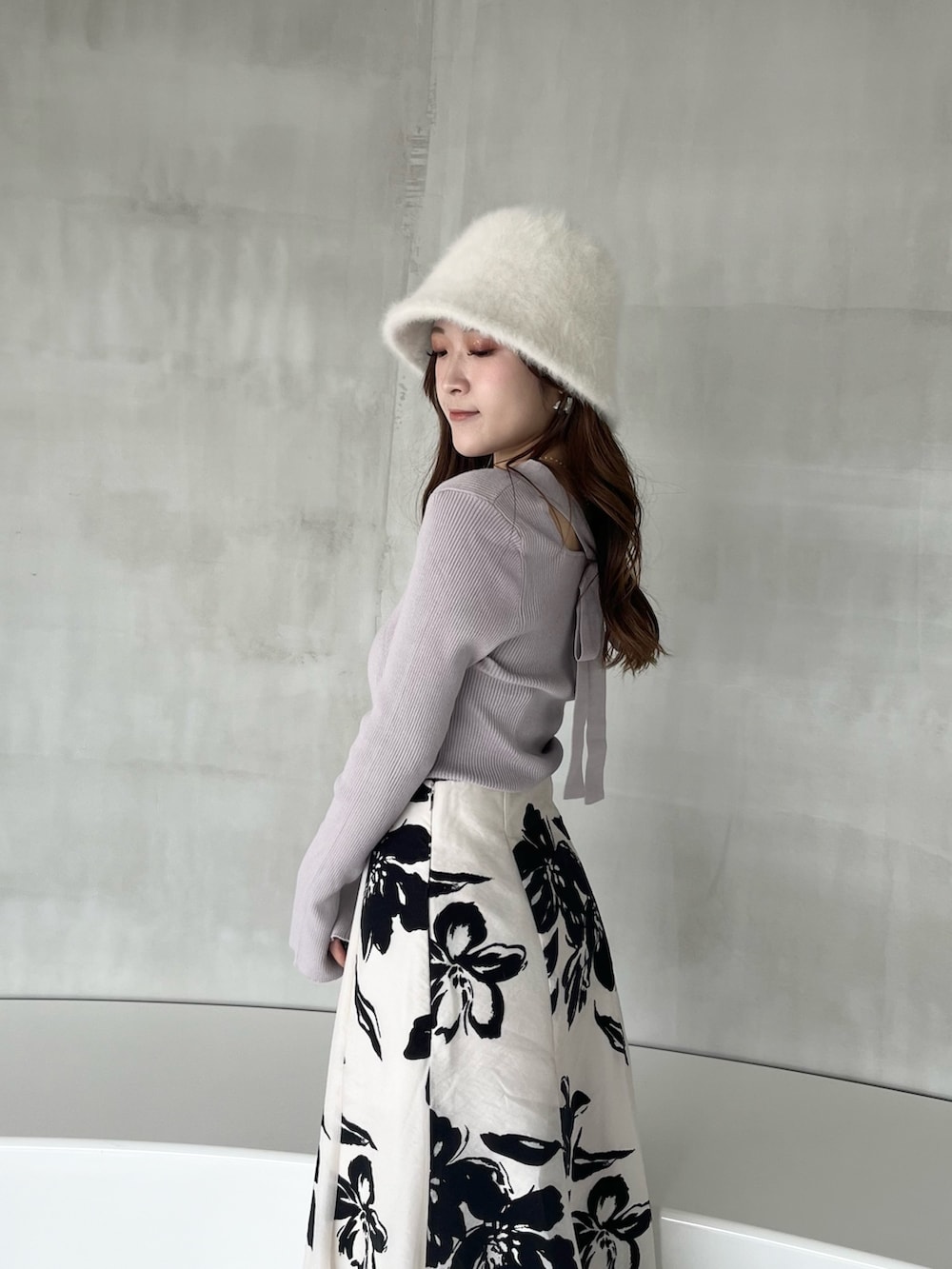 ホワイト系のスカート、パープル系のニット/セーター、ブラック系のブーツを着用したレディースの秋コーディネートの4枚目の写真