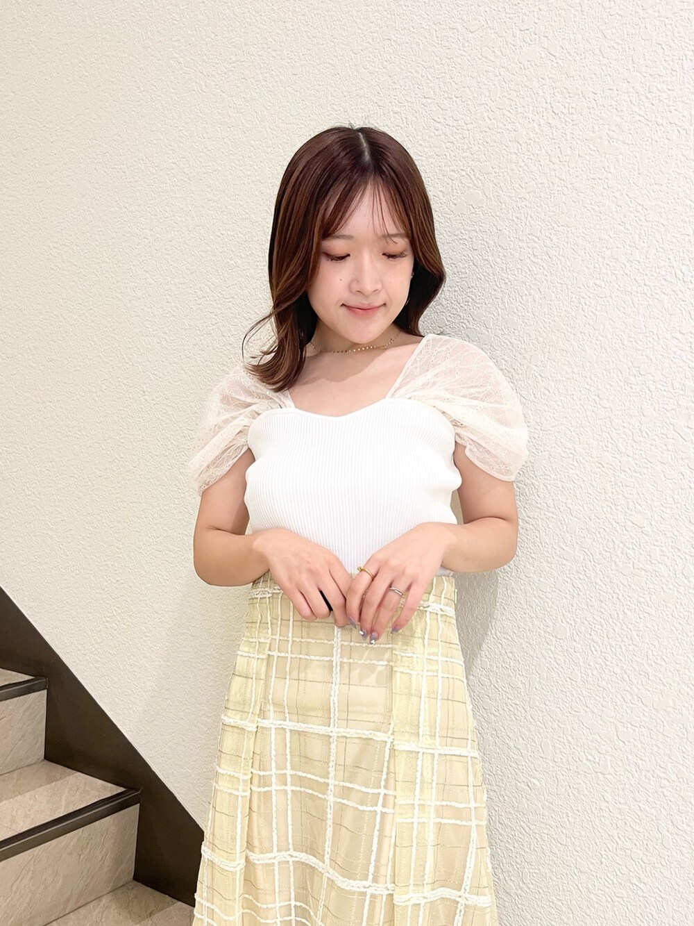 ホワイト系のニット/セーター、イエロー系のスカート、ブラック系のサンダルを着用したレディースの夏コーディネートの5枚目の写真