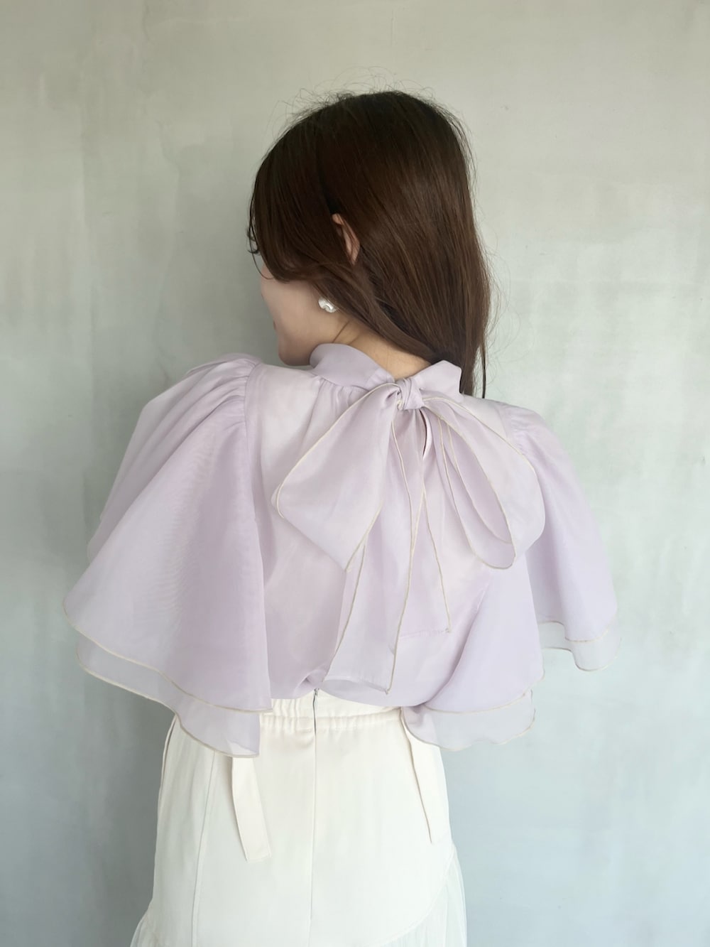 パープル系のシャツ/ブラウス、ホワイト系のスカート、ブラウン系のブーツを着用したレディースの春コーディネートの6枚目の写真