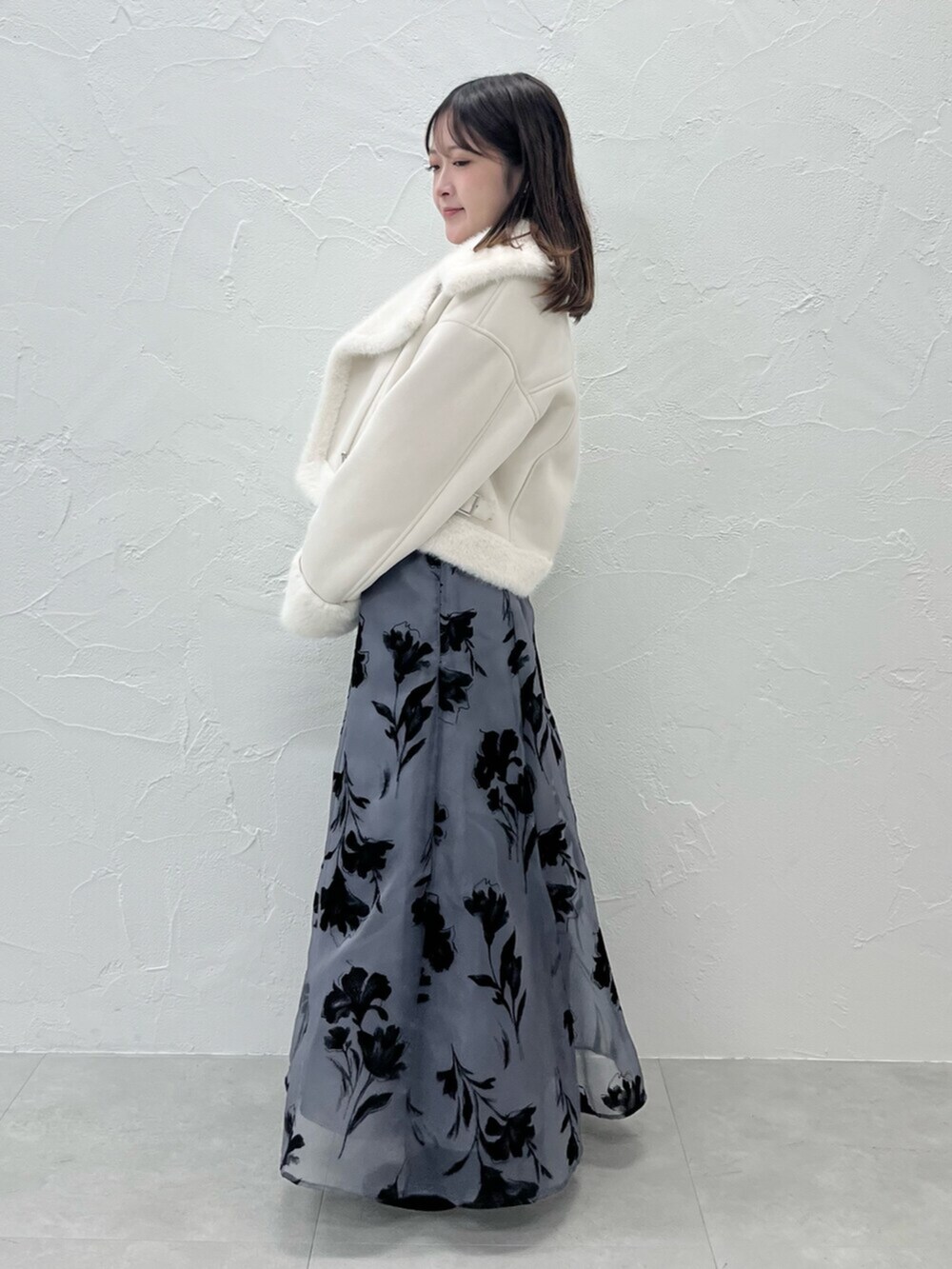 ブラック系のブーツ、ホワイト系のムートンコート、グレー系のニット/セーターを着用したレディースの秋コーディネートの2枚目の写真