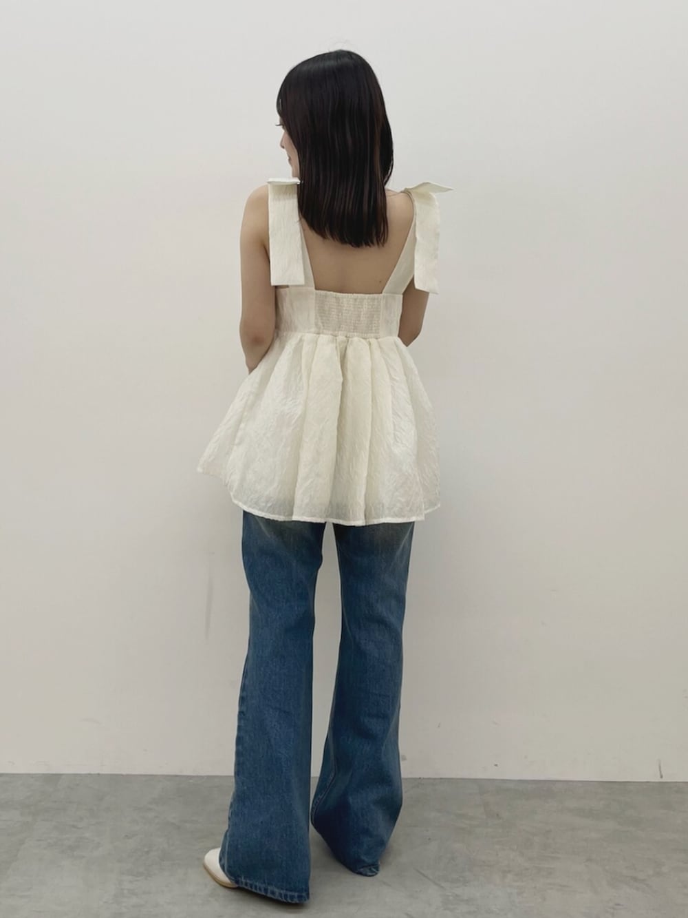 ホワイト系のシャツ/ブラウス、ブルー系のデニムパンツを着用したレディースの夏コーディネートの2枚目の写真