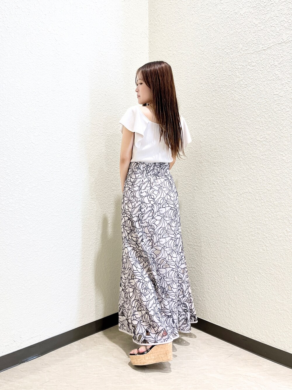 ピンク系のニット/セーター、ベージュ系のスカート、ブラック系のサンダルを着用したレディースの夏コーディネートの3枚目の写真