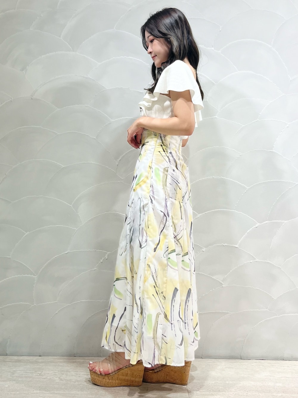 ホワイト系のニット/セーター、イエロー系のスカートを着用したレディースの夏コーディネートの2枚目の写真