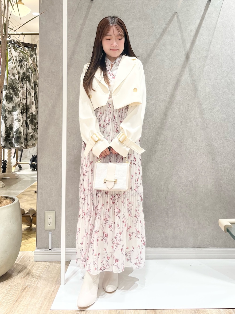 ホワイト系のトレンチコート、レッド系のワンピース、ホワイト系のハンドバッグを着用したレディースの春コーディネートの4枚目の写真