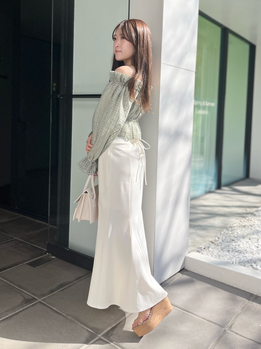 ホワイト系のスカート、グリーン系のシャツ/ブラウス、ベージュ系のショルダーバッグを着用したレディースの冬コーディネートの3枚目の写真