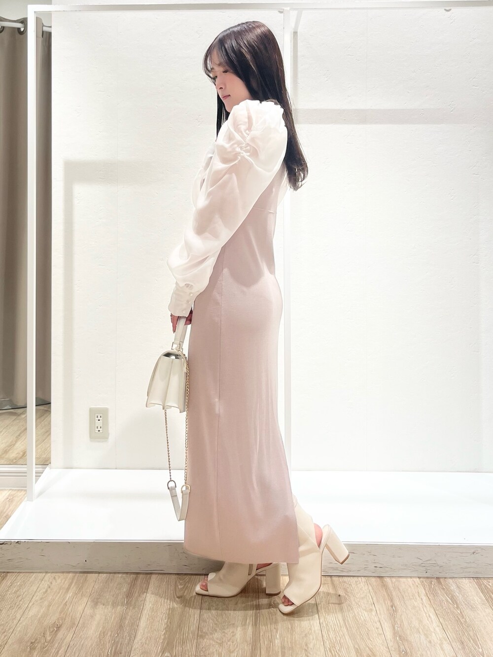 ホワイト系のトレンチコート、ベージュ系のワンピース、ホワイト系のショルダーバッグを着用したレディースの春コーディネートの5枚目の写真