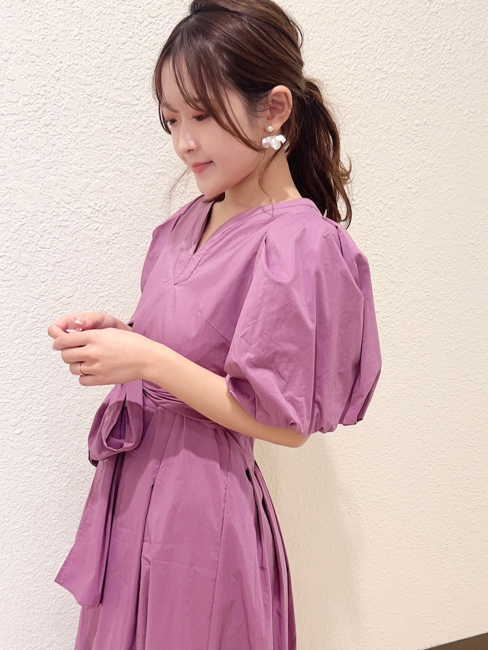 パープル系のワンピース、グレー系のスニーカーを着用したレディースの春コーディネートの3枚目の写真