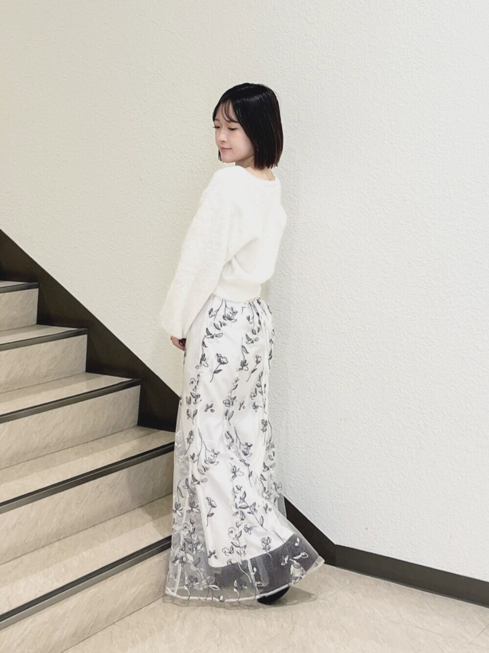 ホワイト系のスカート、ホワイト系のカーディガン/ボレロを着用したレディースの秋コーディネートの2枚目の写真