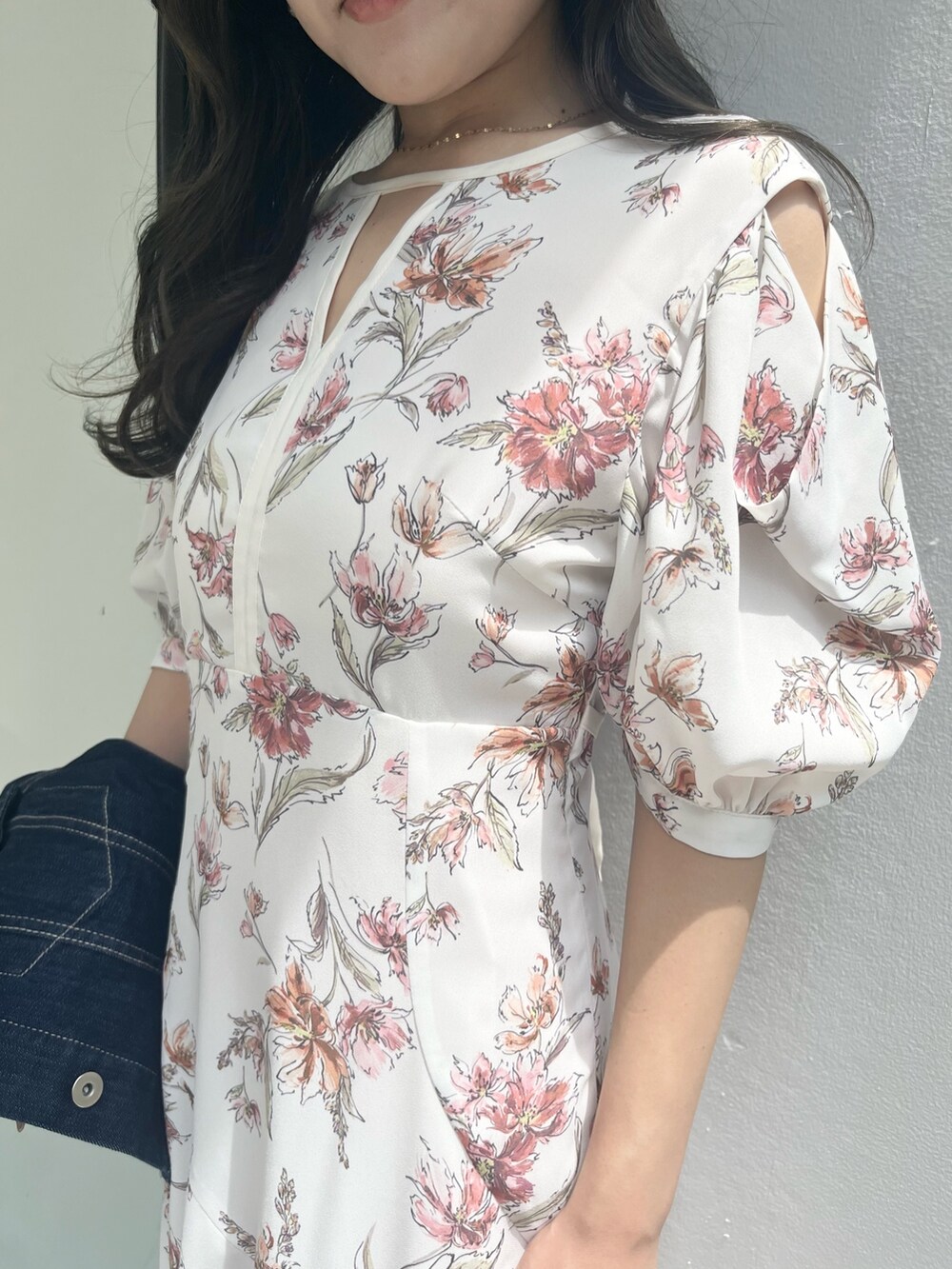 ホワイト系のワンピース、ブルー系のデニムジャケット、ホワイト系のブーツを着用したレディースの夏コーディネートの6枚目の写真