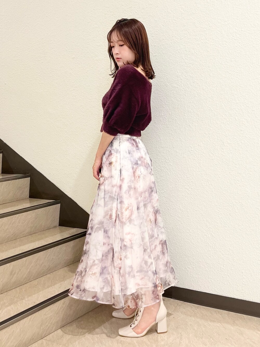 ブラウン系のカーディガン/ボレロ、ホワイト系のスカート、ホワイト系のブーツを着用したレディースの秋コーディネートの2枚目の写真