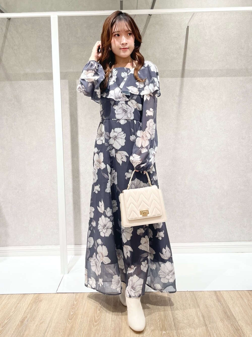 パープル系のチェスターコート、グレー系のワンピース、ホワイト系のショルダーバッグを着用したレディースの秋コーディネートの7枚目の写真