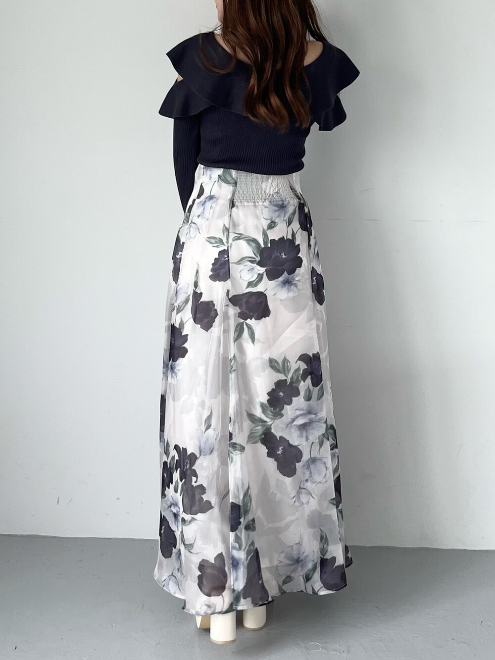 ブルー系のスカート、グレー系のニット/セーター、ホワイト系のブーツを着用したレディースの秋コーディネートの4枚目の写真