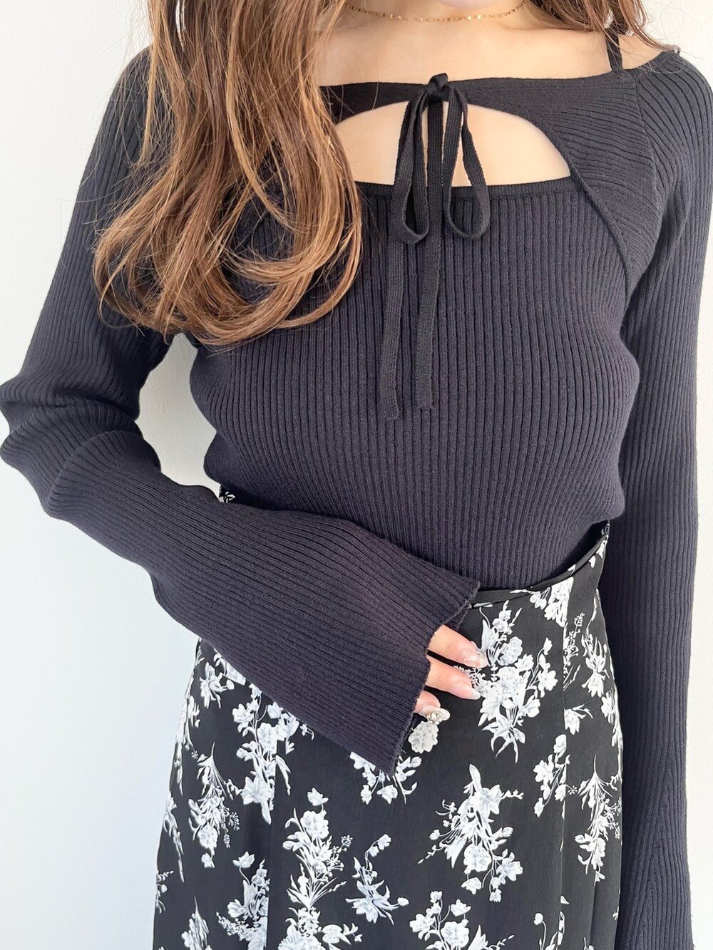 ブラック系のスカート、ブルー系のニット/セーター、ブラック系のブーツを着用したレディースの春コーディネートの7枚目の写真