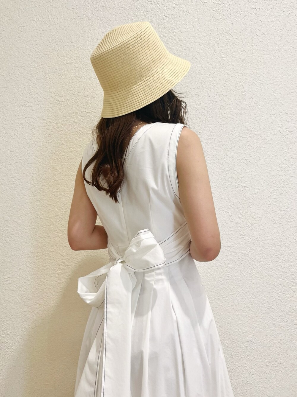 ホワイト系のワンピース、その他のサンダル、ベージュ系のハットを着用したレディースの春コーディネートの5枚目の写真